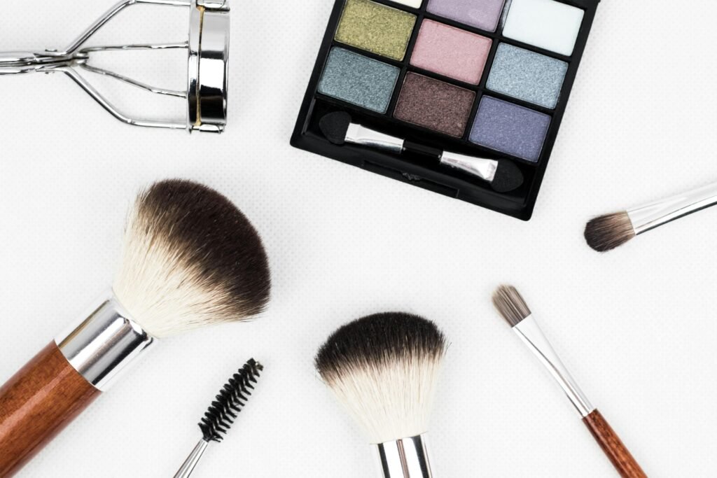 pexels-photo-208052-208052 Top view of makeup tools and a colorful eyeshadow palette arranged artistically.